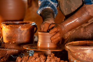 Professional potter making bowl in pottery workshop, studio.