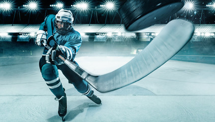 Ice Hockey player athlete in the helmet and gloves on stadium with stick. Action shot. Sport concept. - Powered by Adobe