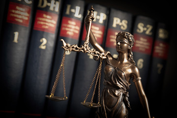 Fototapeta premium Statue of justice on books background