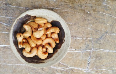 Cashew nuts on ceramic bowl with marble table as copy space background.