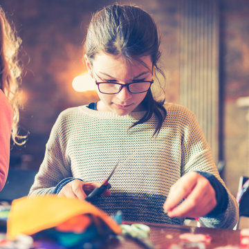 tailor art workshops for children - a girl sewing felt decorations
