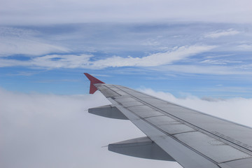 Wing of an airplane flying above the clouds