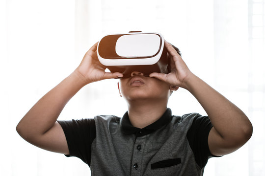 Virtual reality interaction headset by Asian student wearing vr box over technology digital HUD screen background for learning study new simulation sci and game, Futuristic innovation device concept