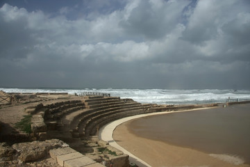 The ruins of a hippodrome and a circus blur the waves of the stormy sea in Caesarea (Israel)