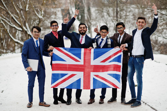 Group Of Six Indian Businessman In Suits Posed Outdoor In Winter Day At Europe With Flag Of Great Britain. Friendly Relations With India And UK.