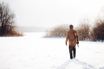 man securing a reserve. man walking on a snowy day. copy space. back view shot