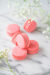 Coral cakes macarons or macaroons on white marble. The concept of Valentines day and spring's celebrating.
