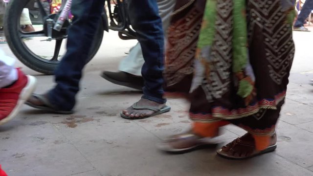 PUSHKAR, INDIA - NOVEMBER 12, 2018 : Feet of people walking in a busy road in the street market in holy city Pushkar, Rajasthan, India