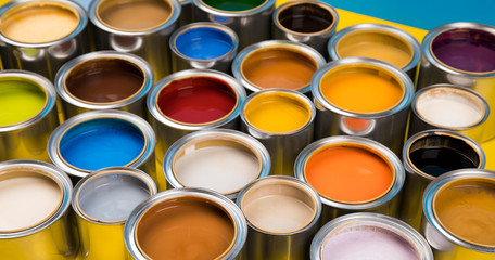 Full Buckets of rainbow colored oil paint on blue  background