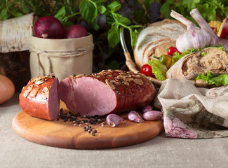 Piece of smoked meat with garlic and spices on a kitchen table.