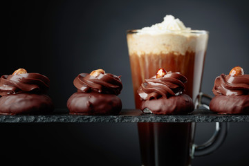  Chocolate dessert with hazelnut and coffee with cream on a black background.
