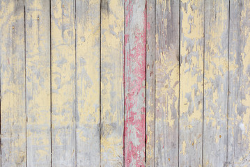 old wooden fence with remains of yellow and pink paint