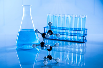 Laboratory beakers, microscope, blue background