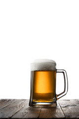Frosty mug of light beer on wood table