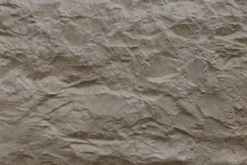 Beige stone surface with deep relief.