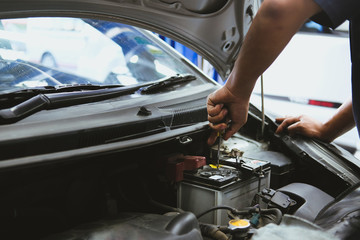 mechanic opening closing checking car battery in automobile repair service