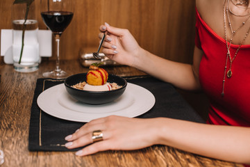 female hand holding spoon near sweet dessert in bowl
