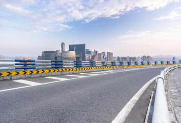 empty asphalt road with city skyline