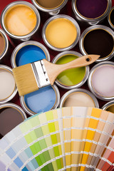Tin cans with paint and brushes, red background