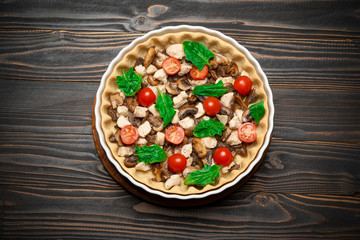 Traditional quiche tart in baking form with filling