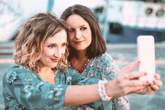 two friends taking photo with mobile phone