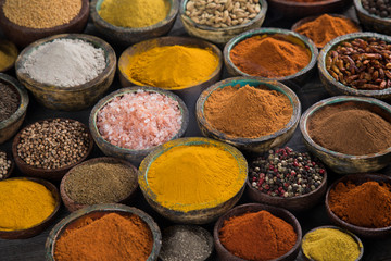 Assortment of spices in wooden bowl background