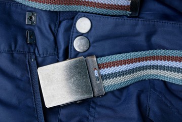 blue trousers with buttons and zip with a striped belt with an iron buckle