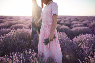 Young girl in the romantic dress and her man in the lavender fields