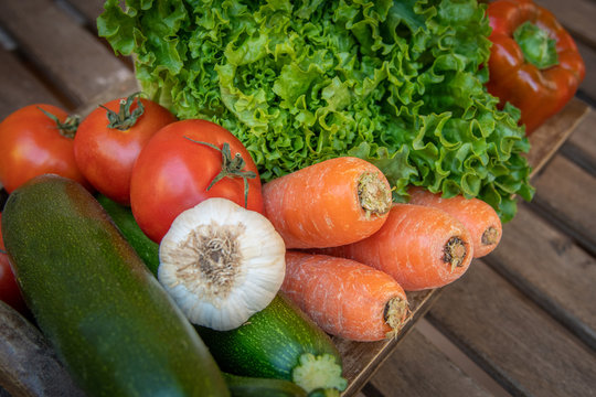 View from the top of a wooden table with various vegetable tray. Close up food image with colorful vegetables. Composition of a group vegetarian healthy foods. Concept of health fresh foods