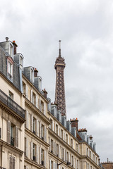 Obraz premium view of the eiffel tower through the roofs of houses