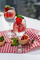 Glass of strawberry cocktail soda placed on a plaid tablecloth .