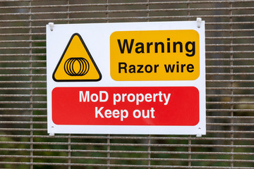 Instow, North Devon, England, UK. January 2019. Ministry of Defence warning sign of razor wire.