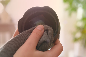 Cleaning DSLR lens with microfiber cloth