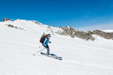 Fototapeta na wymiar Female back-country skier tackling a steep slope.