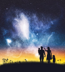 Obraz na płótnie Canvas Parents with their children on a night sky.