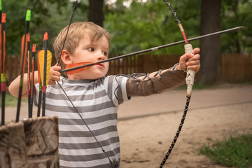 Boy with a bow and arrow. Children and sports.