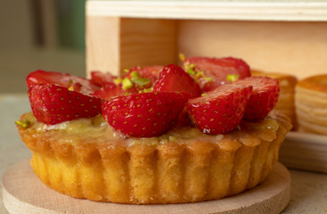 Cake with strawberries and barrels of dough close-up.