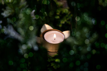 burning candle on green background