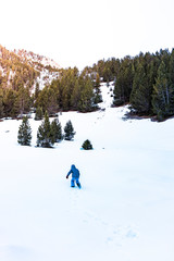 Child climbing a snowy mountain in winter