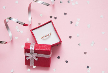 Red gift box with a jewelry on festive background.
