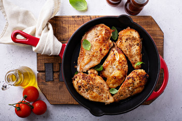 Cooked chicken breast seared in a cast iron skillet overhead © fahrwasser