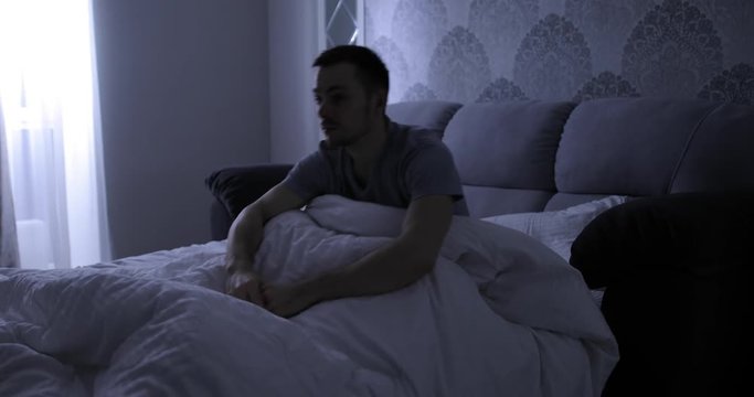Bad dream, man abruptly wake up in his bed at night