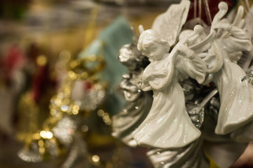 Fototapeta na wymiar Sale of Christmas toys in the supermarket. Ceramic angel - New Year's toy. 