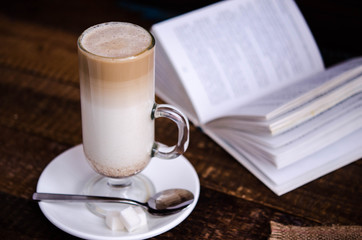 Glass latte with a book in the background