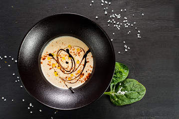 Tasty cream soup on black background