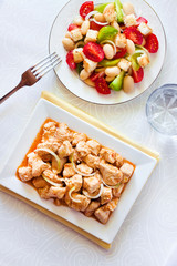 Turkey stew in tomato mustard sauce with onion on square plate