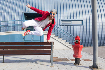 young boy with red jacket and cheerful sunglasses near a hydrant