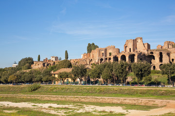 View of the Circus Maximus terrain and the ruins of the Temple of Apollo Palatinus in Rome, Italy. Shot in afternoon sunlight and set against a clear blue sky. 