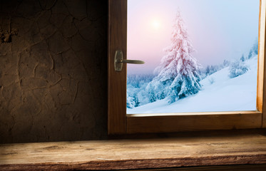 Empty wood table top on blur window view with pine tree in snow fall of morning winter season.For christmas day background and new year concept.
