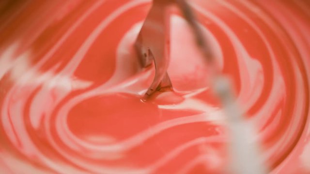 Orange liquid is added into lab blender to a white cream at the lab